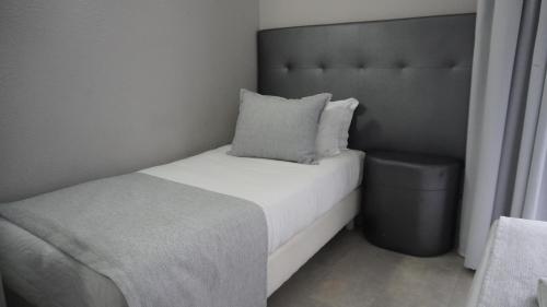a small bedroom with a bed and a trash can at Hotel Senhor de Matosinhos in Matosinhos