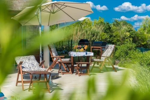 a patio with a table and chairs and an umbrella at Villa Miri Lavender in Privlaka