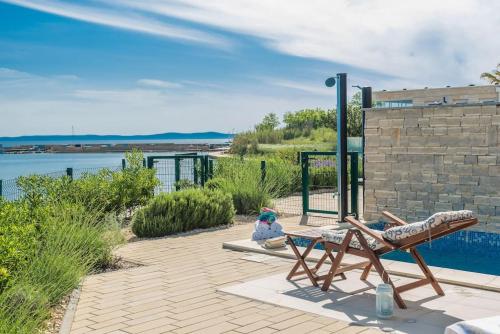 a person sitting in a chair next to a pool at Villa Miri Lavender in Privlaka
