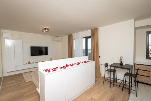 a white kitchen with red flowers on a counter at Sinfonia Lux 1205 in Sajmište