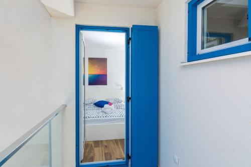 a blue door in a hallway with a mirror at Villa Miri Lavender in Privlaka