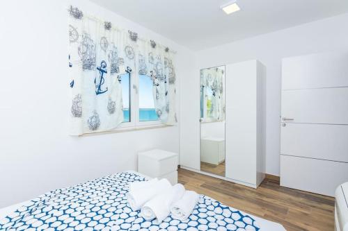 a white room with a bed and a mirror at Villa Miri Lavender in Privlaka