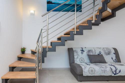 a living room with a couch and stairs at Villa Miri Lavender in Privlaka