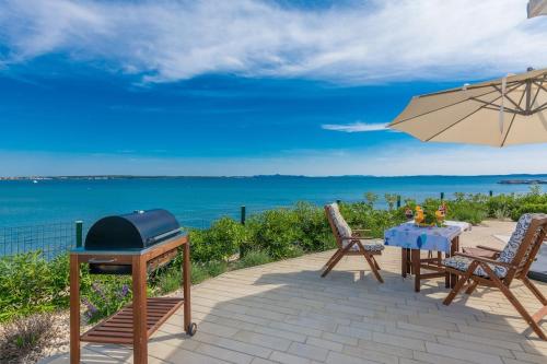 a patio with an umbrella and a table and chairs at Villa Miri Lavender in Privlaka