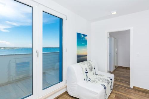a white chair in a room with a window at Villa Miri Lavender in Privlaka
