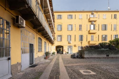an empty alley in front of a yellow building at Spazioso Loft: Coldilana14 in Milan
