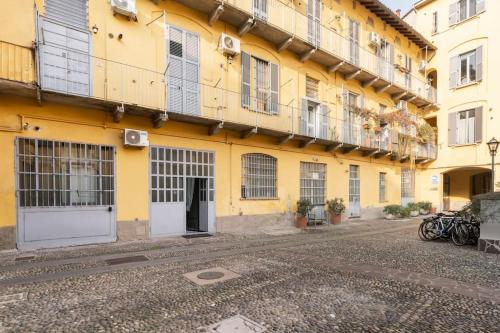 a yellow building with white doors and windows at Spazioso Loft: Coldilana14 in Milan