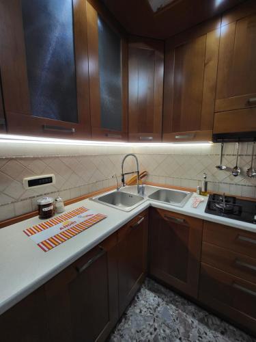 a kitchen with two sinks and wooden cabinets at Angri's Guest House in Angri
