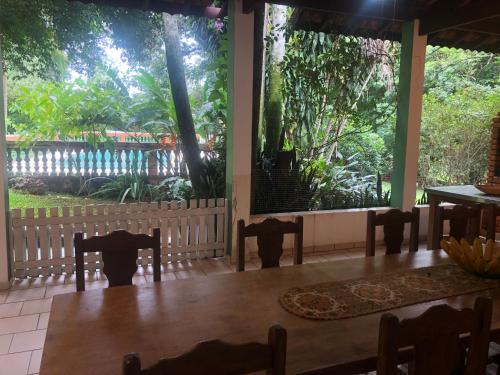 een eetkamer met stoelen en een groot raam bij Sítio charmoso in Jarinu
