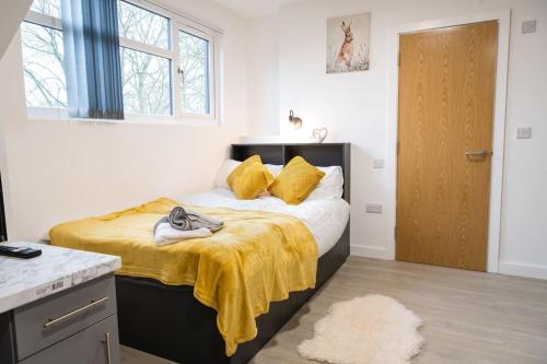 a bedroom with a bed with a yellow blanket on it at Sleek and Stylish Studio: Old Trafford in Manchester