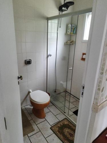 a bathroom with a toilet and a glass shower at Sítio charmoso in Jarinu