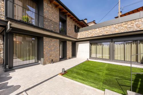 a courtyard with a lawn in front of a house at Cases Cerdanya Mountain Residences in Bellver de Cerdanya 