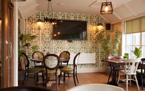uma sala de jantar com mesa e cadeiras em The Kings Head Wroxham by Greene King Inns em Wroxham