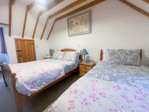 a bedroom with two beds and a lamp on a table at Bayview Holiday Home No 39 by Trident Holiday Homes in Dunmore East