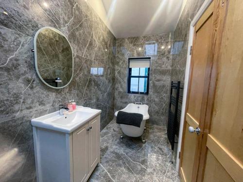 bagno con lavandino e specchio di Bayview Holiday Home No 39 a Dunmore East