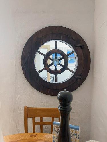 a wooden wheel hanging on a wall above a table at Bayview Holiday Home No 39 by Trident Holiday Homes in Dunmore East
