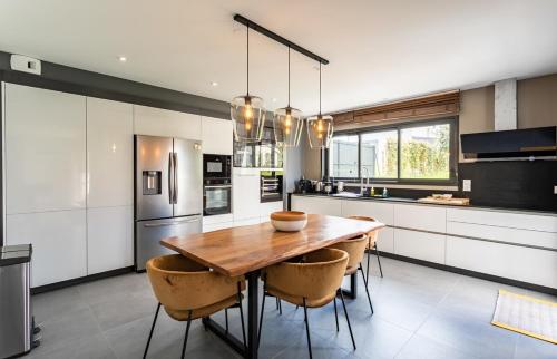 cocina con mesa de madera y algunas sillas en Villa Ty Laouen- Maison moderne 3 chambres jardin, en Dinard