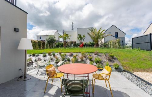 un patio con una mesa, sillas y una fuente. en Villa Ty Laouen- Maison moderne 3 chambres jardin, en Dinard