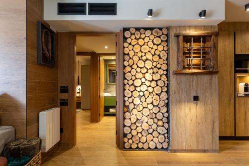 a room with a wall filled with logs at Cases Cerdanya Mountain Residences in Bellver de Cerdanya 