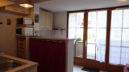 eine Küche mit einem Waschbecken und eine Tür zu einem Balkon in der Unterkunft Résidence Eugenie - 2 Pièces pour 4 Personnes 964 in Guchen