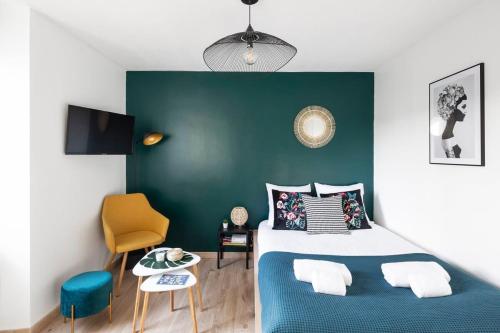 Un dormitorio con una cama azul y una pared verde en L'éden studio moderne et lumineux proche centre, en Rennes