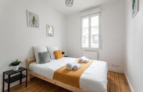 um quarto com uma cama com duas toalhas em Le Gardelle - Jolie maison de ville (2 chambres) em Saint Malo