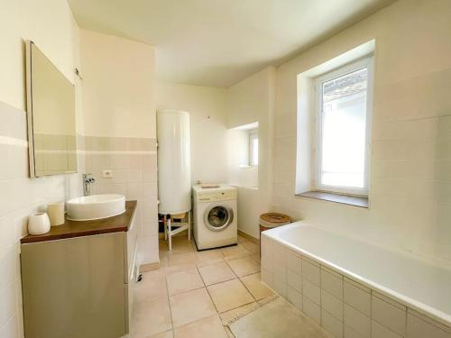 een badkamer met een wastafel en een wasmachine bij Charmante Maison de Village - Plages 30' in Autignac