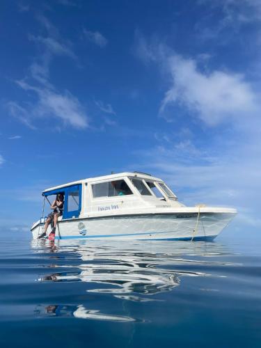 a person standing in the front of a boat in the water at Huvan Inn in Fulidhoo