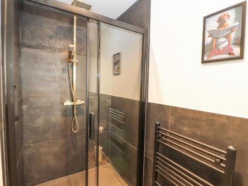 a shower with a glass door in a bathroom at The Hideaway Waverton Villa in Wigton