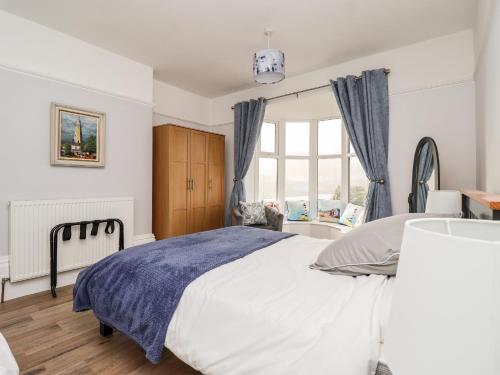 a bedroom with a large bed and a window at 46 The Promenade in Withernsea