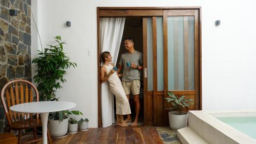 un homme et une femme debout à l'entrée d'une maison dans l'établissement Lugadia Villas, à El Nido