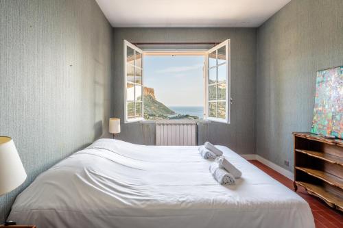 ein Schlafzimmer mit einem Bett mit Blick auf das Meer in der Unterkunft Les Aiguadines par Dodo à Cassis in Cassis