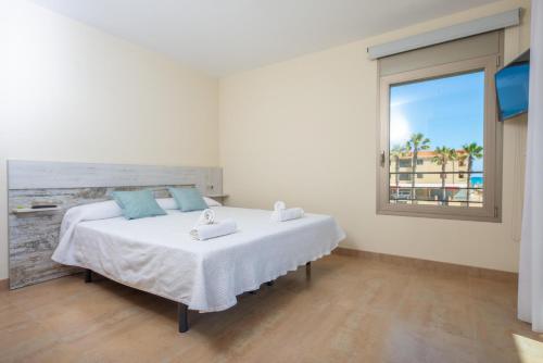 sypialnia z łóżkiem i widokiem na ocean w obiekcie Antonia w Can Picafort