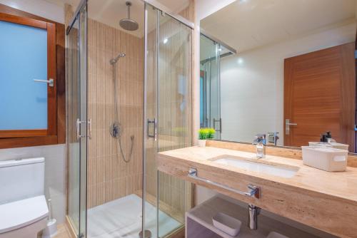 W łazience znajduje się szklana kabina prysznicowa i umywalka. w obiekcie Antonia w Can Picafort
