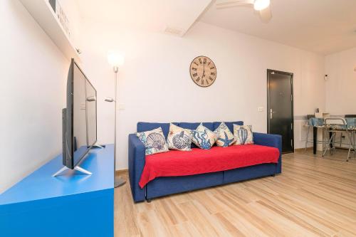 een woonkamer met een blauwe bank en een tv bij Loving Rota in Rota