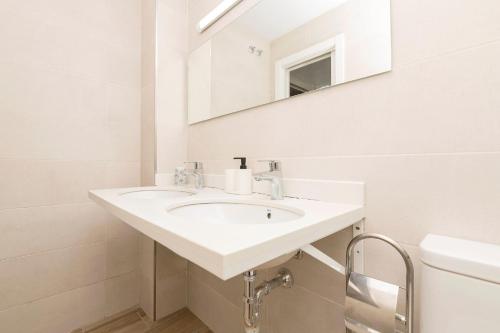 a white bathroom with a sink and a mirror at Loving Rota in Rota