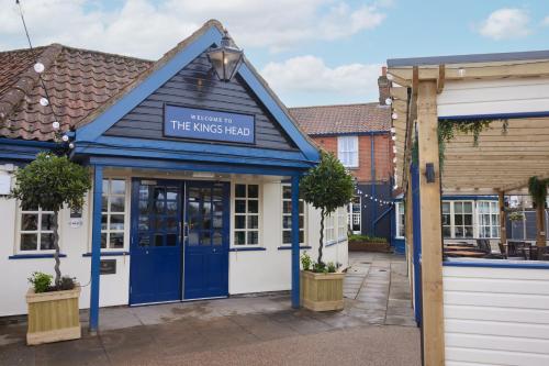 a building with a blue door with a sign on it at The Kings Head Wroxham by Greene King Inns in Wroxham