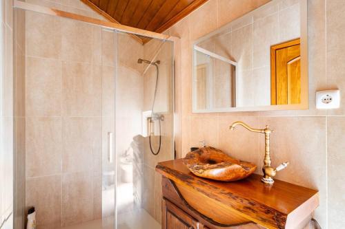 uma casa de banho com um lavatório e um chuveiro em Segredos da Montanha - Mangualde em Mangualde