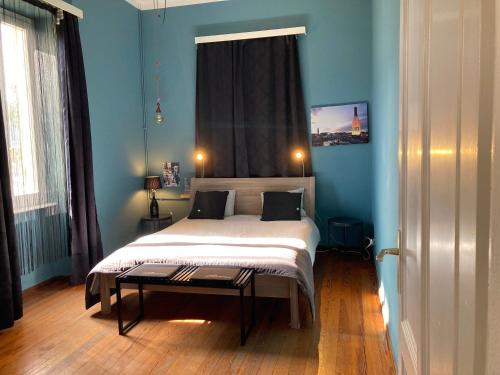 1 dormitorio con 1 cama en una habitación azul en Villa Art'è, en Locarno