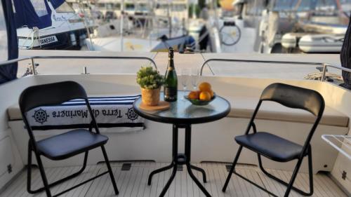a table with two chairs and a bottle of wine on a boat at Cosy and Homey Houseboat Castelldefels in Barcelona