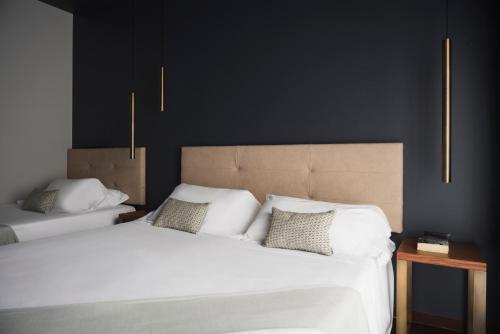 two beds in a bedroom with black walls at The Regent Boutique Hotel & Spa PRE OPENING in San Marino