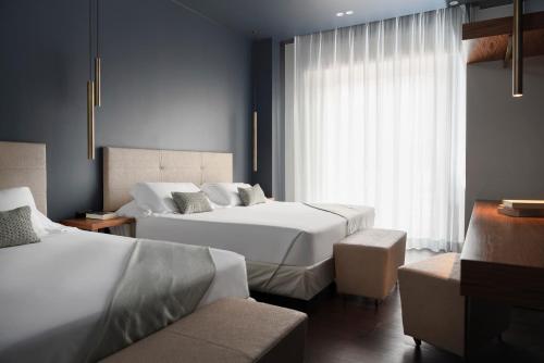 a hotel room with two beds and a window at The Regent Boutique Hotel & Spa PRE OPENING in San Marino