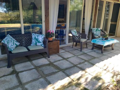 a patio with two chairs and a couch and a table at Appartamento in Villa Siciliana in Ognina