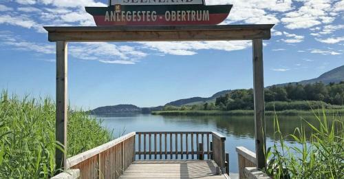 a wooden dock with a sign on top of a lake at Urlaub am See Seehaus Salzburg Mattsee Obertrum Seeham Salzburger Seenland in Obertrum am See