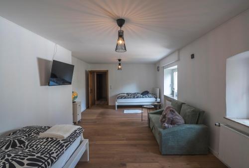 uma sala de estar com uma cama e um sofá e um quarto em Das Schmitz Haus, Ferienhaus em Meckel