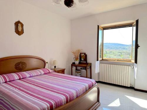 a bedroom with a bed and a large window at Tuscany Panoramic View - Relax in Val D'Orcia in Seggiano