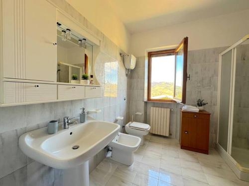 a white bathroom with a sink and a toilet at Tuscany Panoramic View - Relax in Val D'Orcia in Seggiano