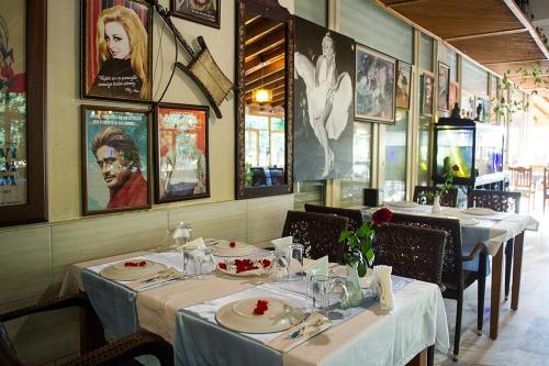 グムルドゥルにあるGumuldur Deniz Kızı Green Gardenの白いテーブルクロスのシドウシドウシドウのテーブル2台付きのレストラン