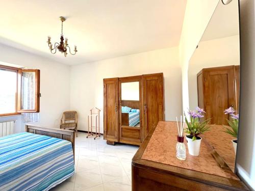 Un dormitorio con una cama y una mesa con flores. en Tuscany Panoramic View - Relax in Val D'Orcia, en Seggiano