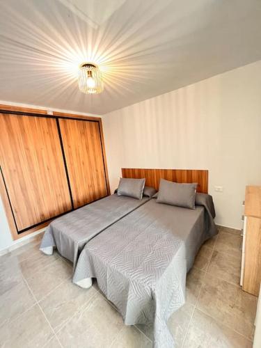 1 dormitorio con 2 camas y lámpara de araña en Descanso y Encanto en Vilaflor, en Vilaflor